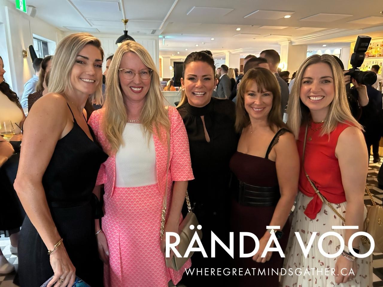 Five guests smiling together in the reception room.