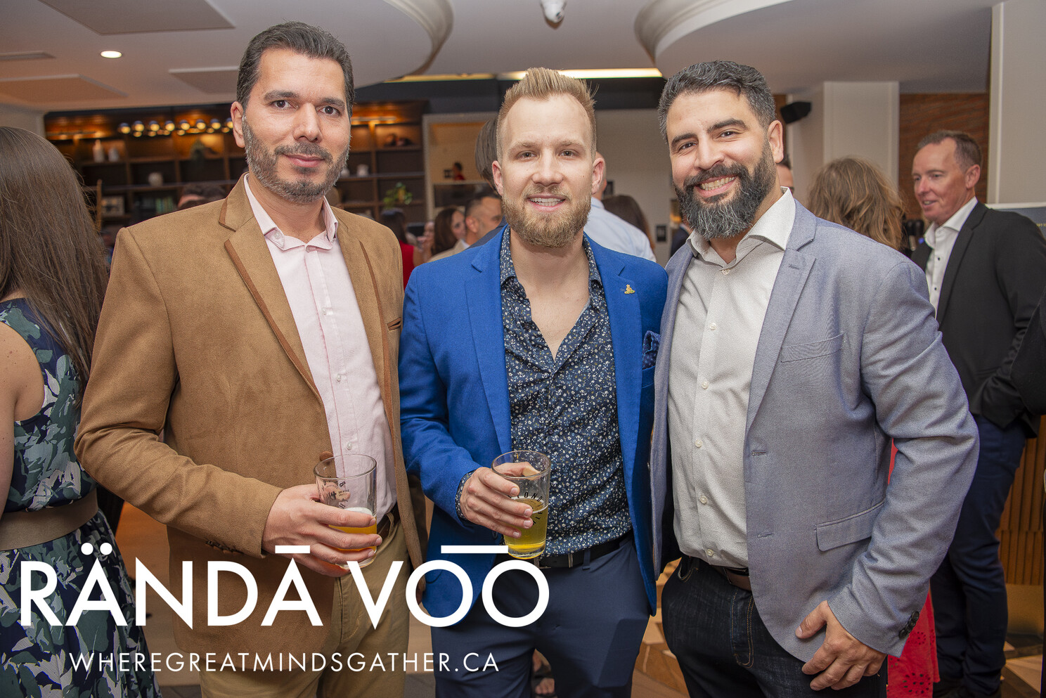 Three guests in tan, blue and grey jackets at the reception.
