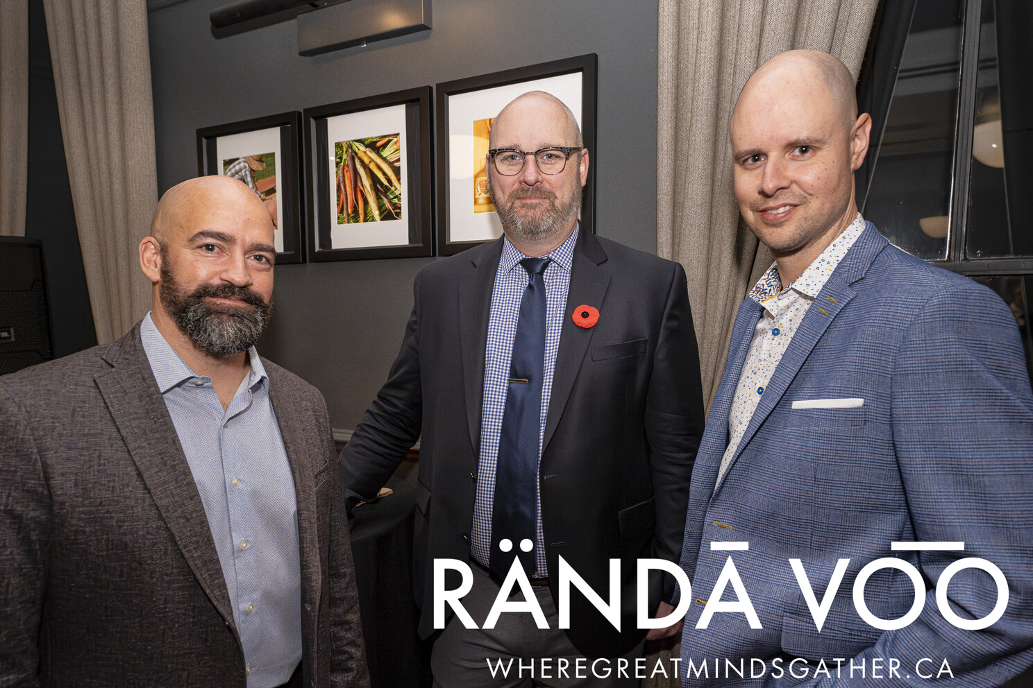 Three guests standing beside framed artwork at Business. Bubbles. Seafood.