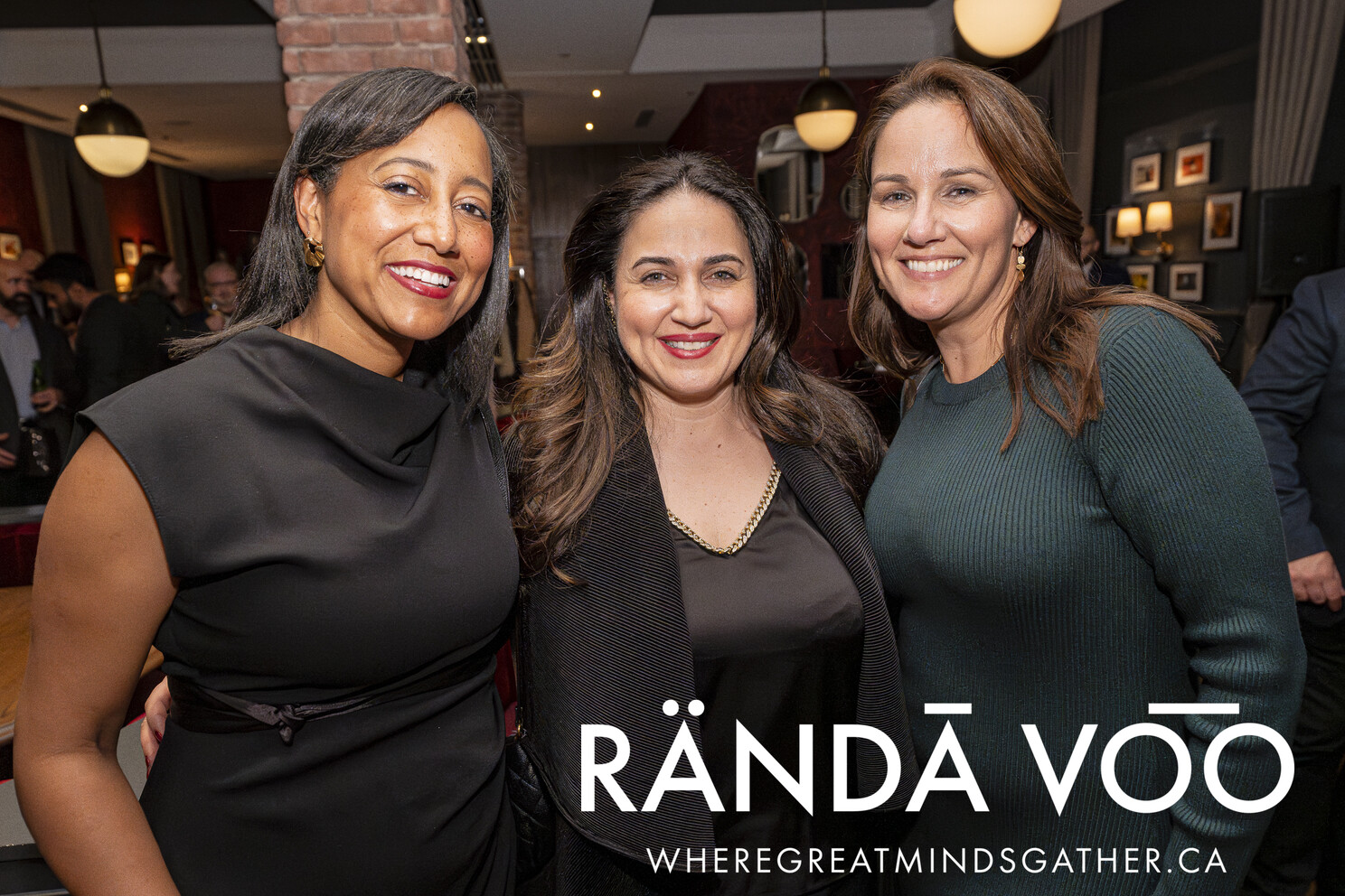 Three guests smiling together at the Business. Bubbles. Seafood reception.