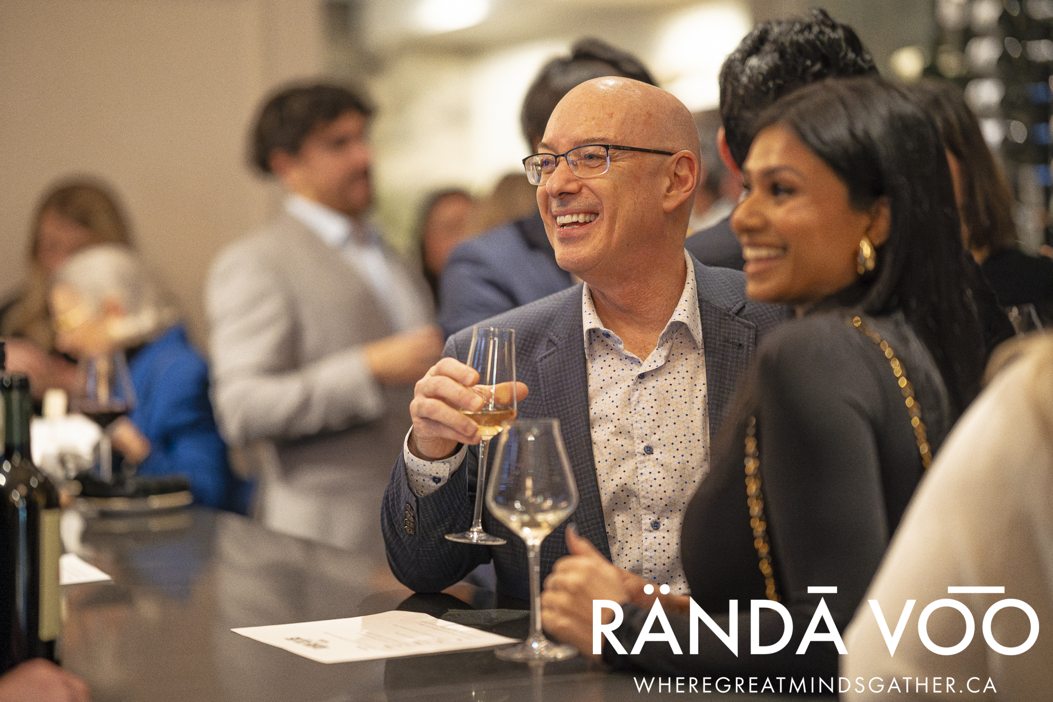 Two guests enjoying wine and conversation at the tasting counter.