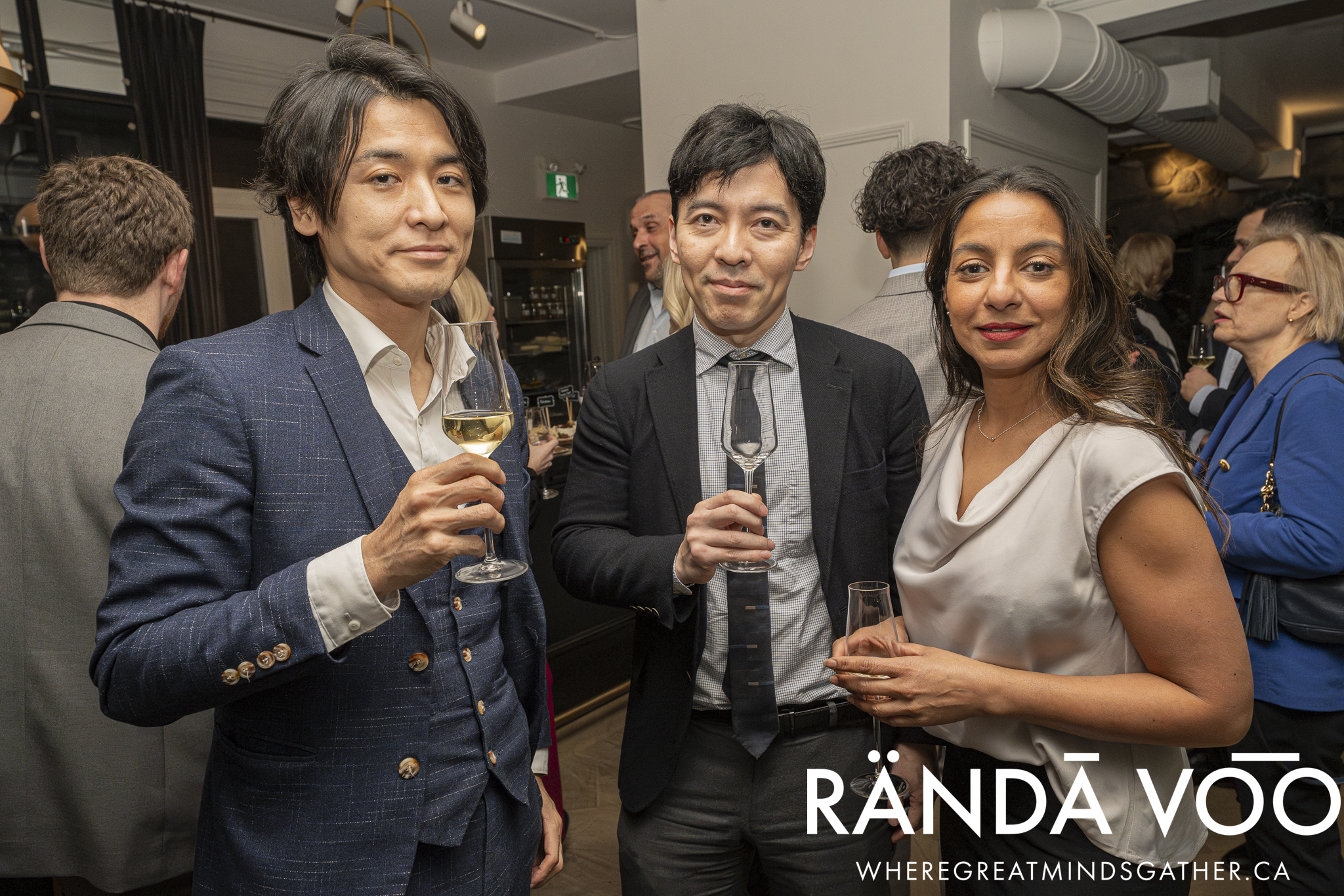 Three guests holding wine glasses at the Prestige reception.