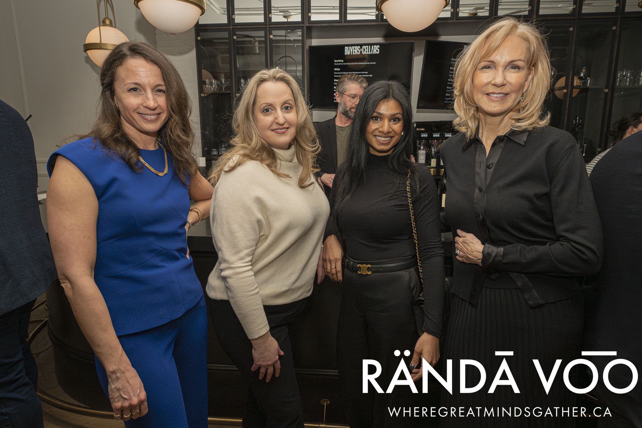 Four guests posing together at the Prestige wine-tasting reception.