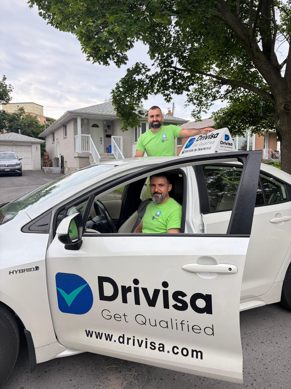 Ali Zaydan and a Drivisa team member with a branded driver-training vehicle.
