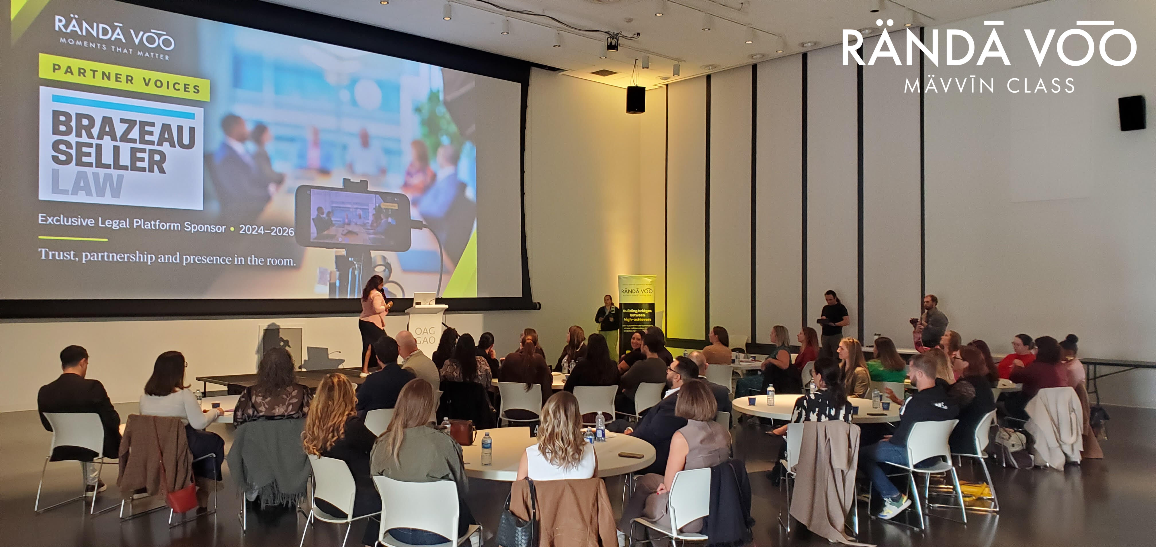 Guests seated around tables facing the stage at MÄVVĪNCLASS The Capacity Room, Ottawa Art Gallery, September 22, 2026.