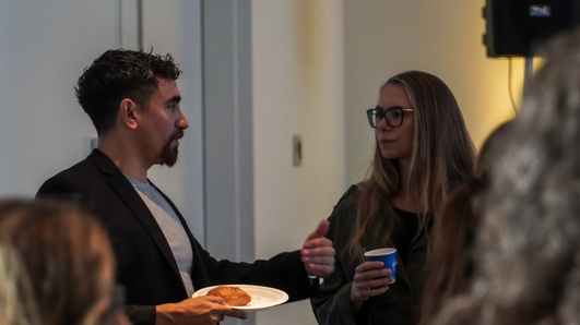 Two guests in conversation over coffee and breakfast during opening networking at MÄVVĪNCLASS The Capacity Room.