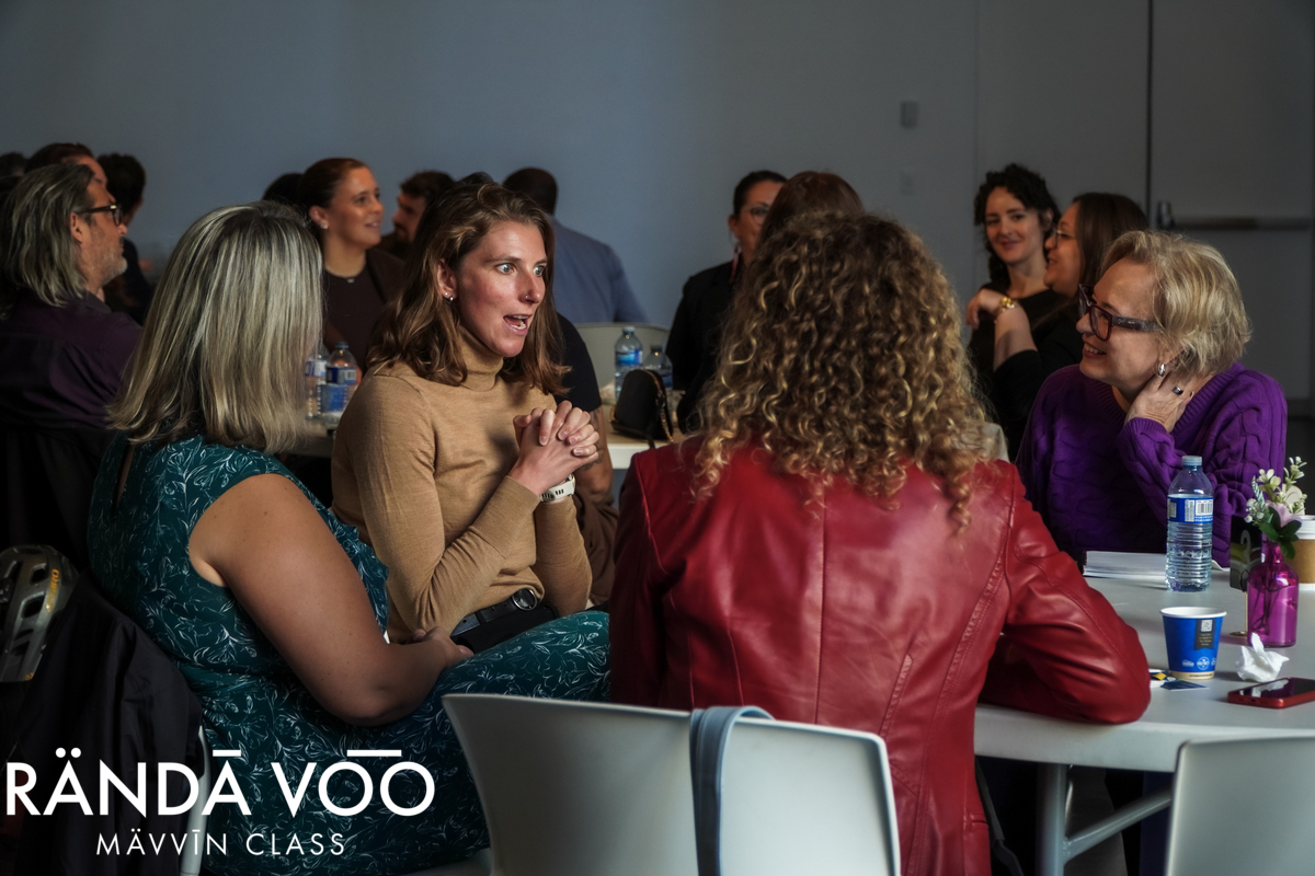 Guests exchanging ideas around a table during the MÄVVĪNCLASS peer dialogue.