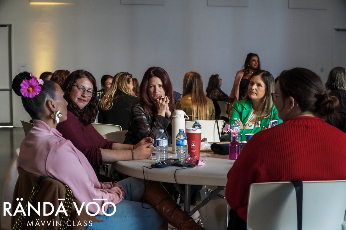 Guests engaged in peer conversation around a table at MÄVVĪNCLASS The Capacity Room.