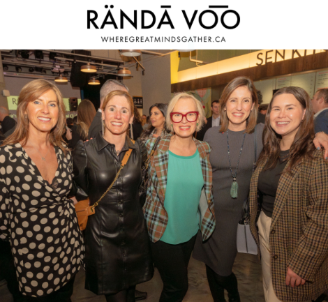 Five guests smiling together at Queen St. Fare beneath RÄNDĀ VO͞O branding.
