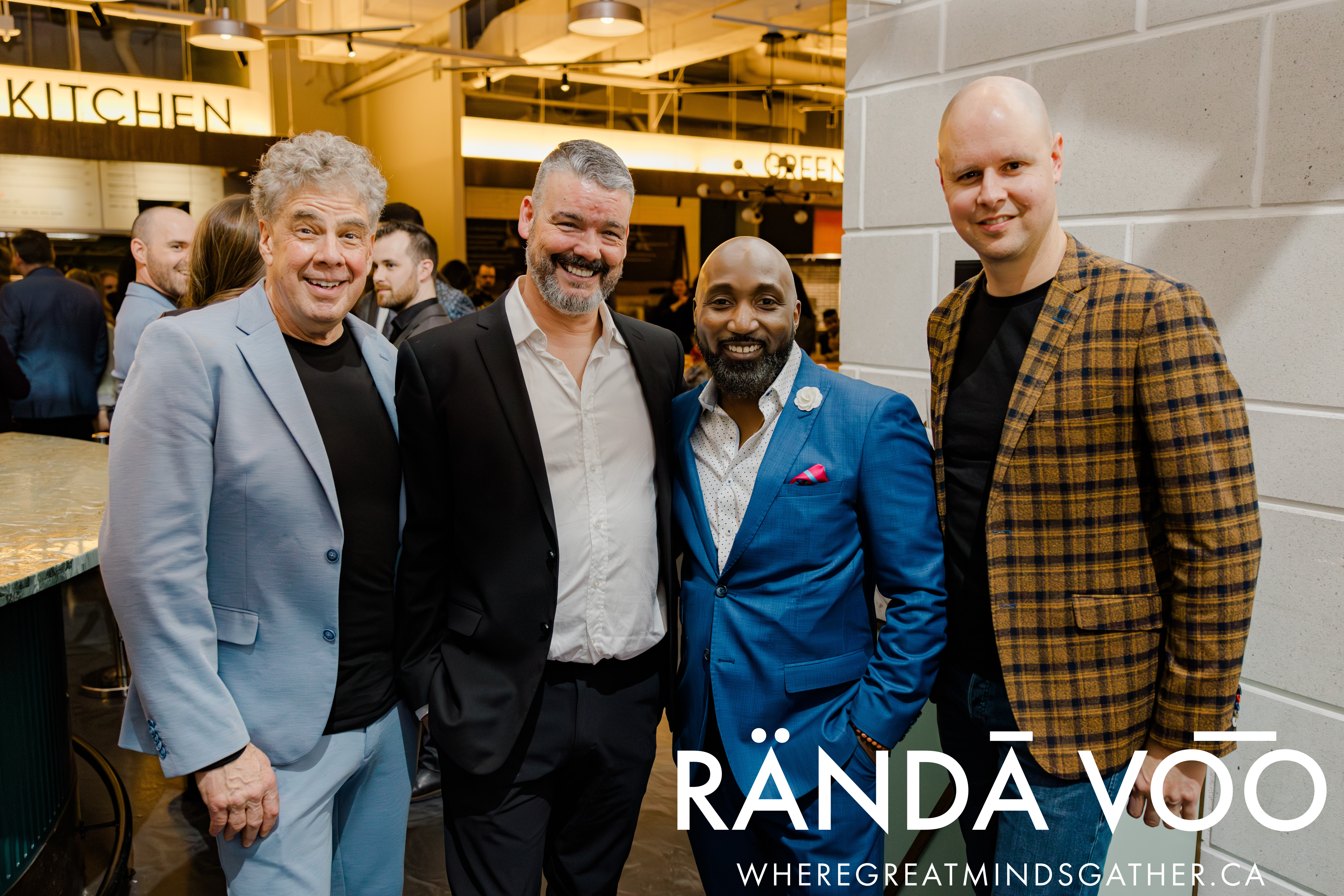 Four guests smiling together at Queen St. Fare, with RÄNDĀ VO͞O branding.