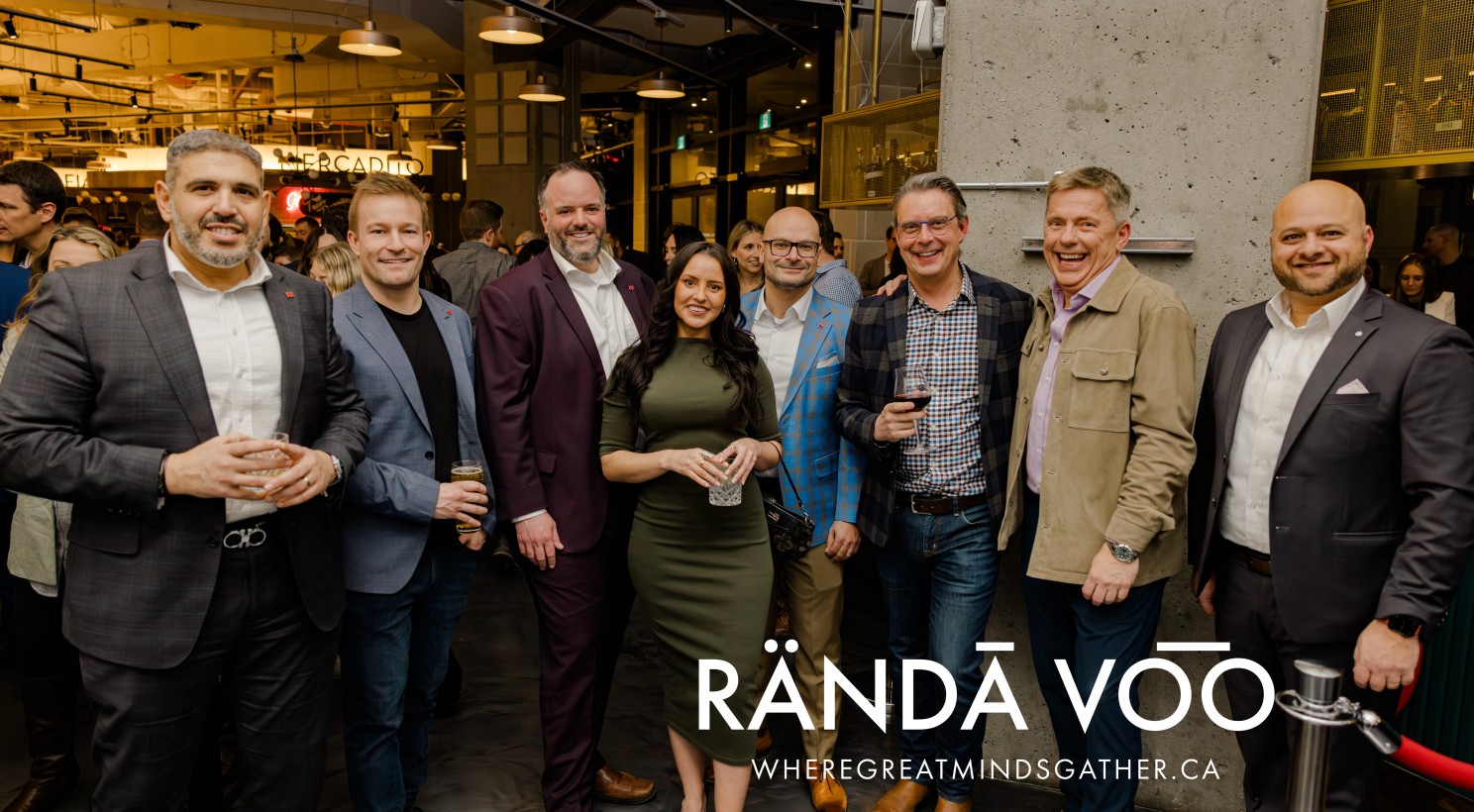 Eight guests posing together at Queen St. Fare, with RÄNDĀ VO͞O branding.
