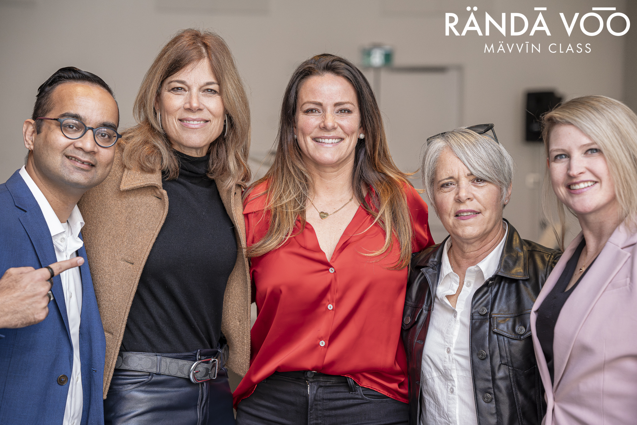 Five RÄNDĀ VO͞O business community attendees posing together at a MÄVVĪNCLASS event.