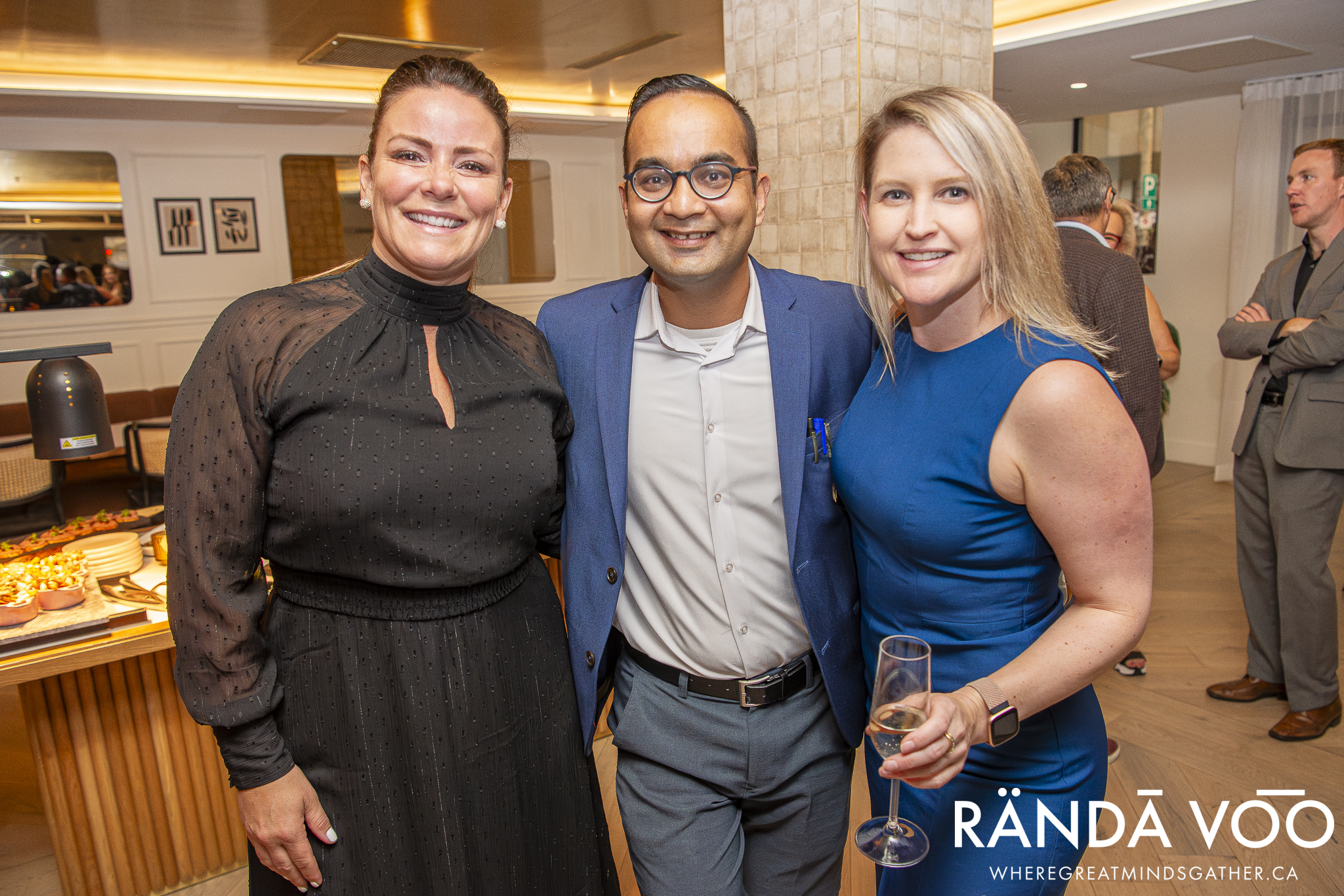 Three RÄNDĀ VO͞O business community attendees posing together during a networking reception.