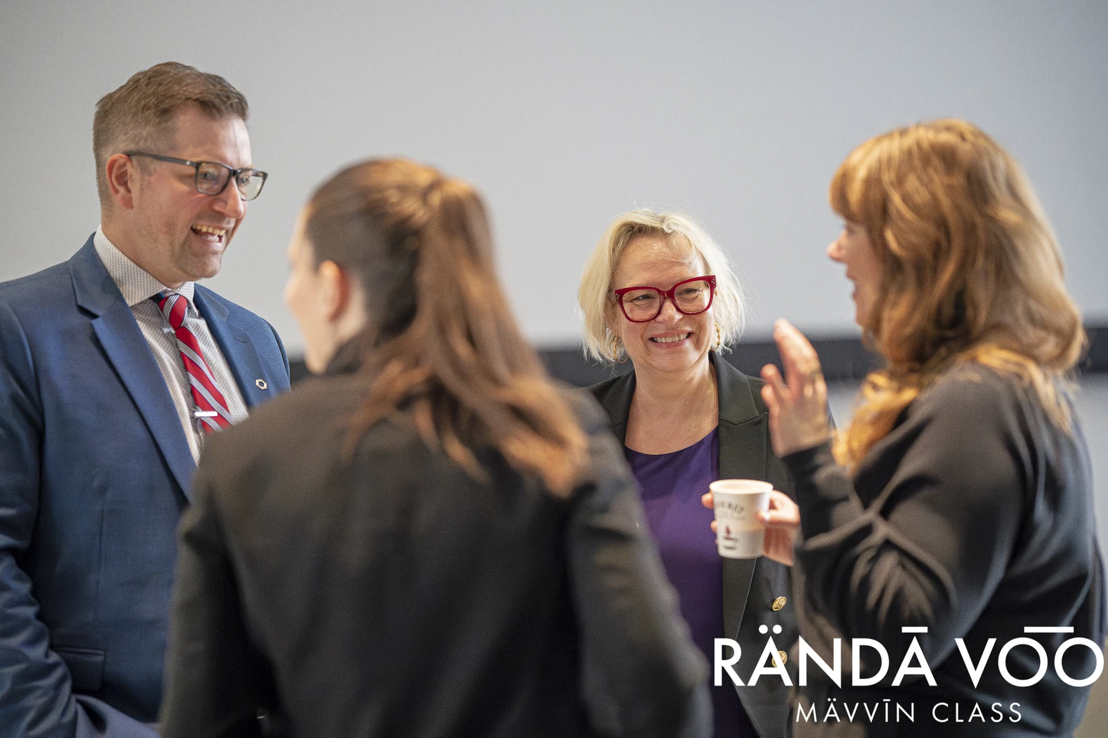 RÄNDĀ VO͞O business community attendees sharing a conversation over coffee at a MÄVVĪNCLASS gathering.