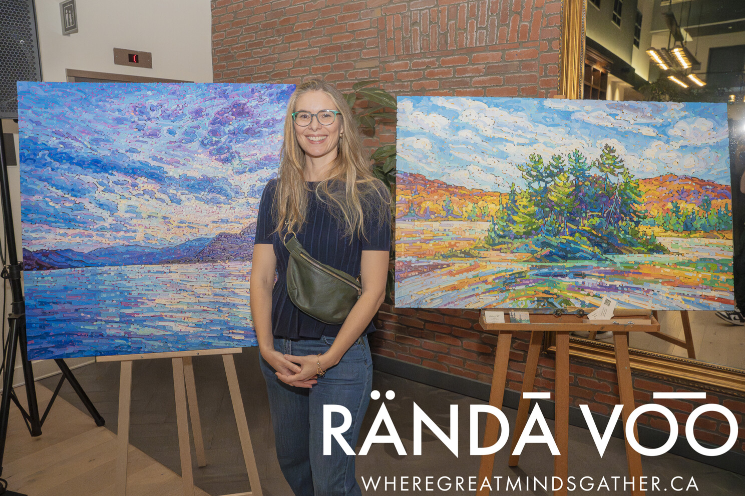 A guest standing between two colourful landscape paintings at the grand finale.