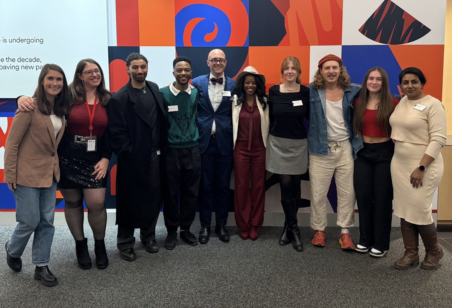 Hailey Hechtman with a group of collaborators in Quebec, standing before a colourful geometric wall.