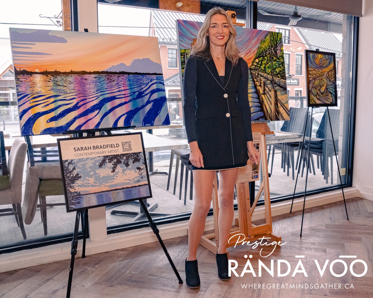 A woman standing beside colourful paintings displayed at the Prestige reception in Manotick.