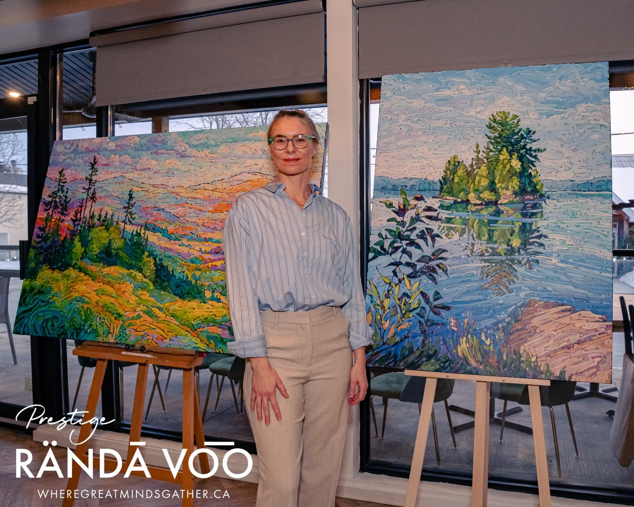 A woman standing between two landscape paintings at the Prestige reception in Manotick.