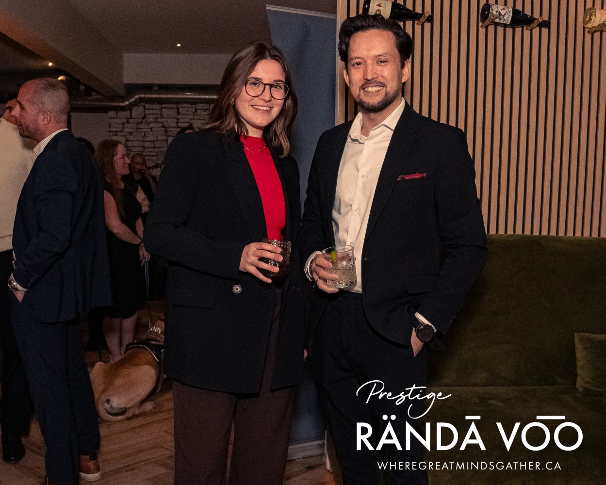 Two guests posing with drinks at the Prestige reception at HEIST Manotick.