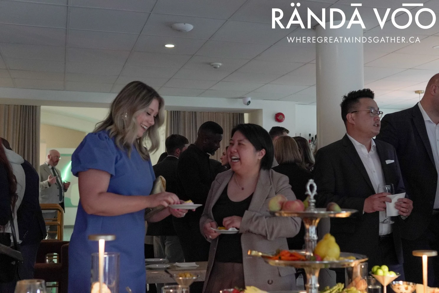 Guests laughing and talking beside the grazing table at Parlour, with RÄNDĀ VO͞O branding.