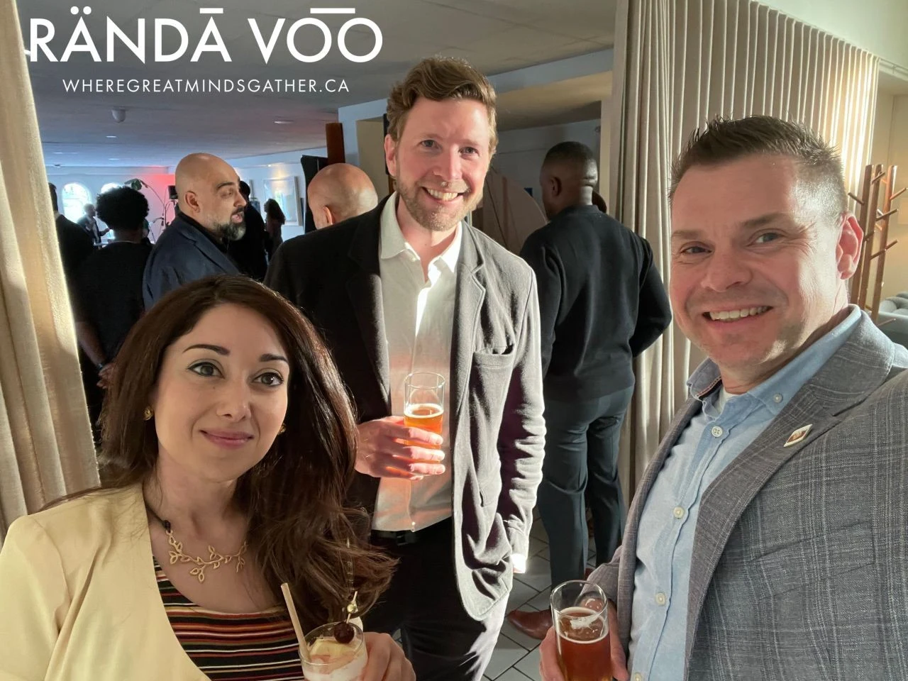 Three guests posing together with drinks at Parlour, with RÄNDĀ VO͞O branding.